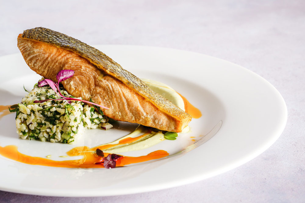 Grilled salmon plated with herbs